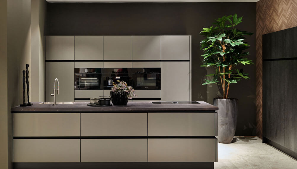 Een legergroene moderne keuken waarin de werkdriehoek van een keuken goed is toegepast