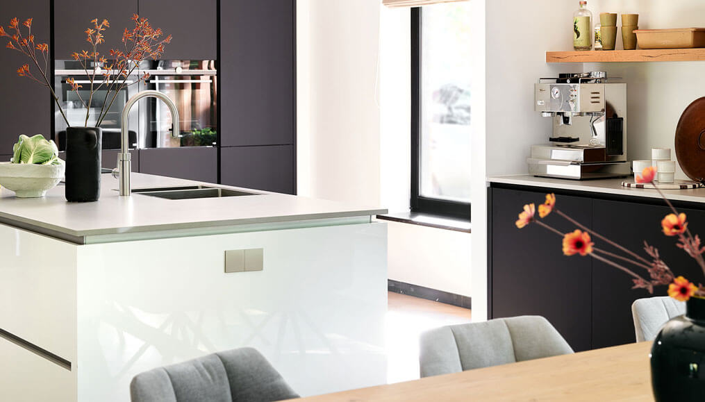 Een moderne keuken met keukeneiland met genoeg stroompunten, die mooi zijn weggewerkt, voor alle apparatuur.