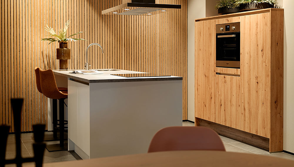 Een modern landelijke eiland keuken met warme houten kastenwand